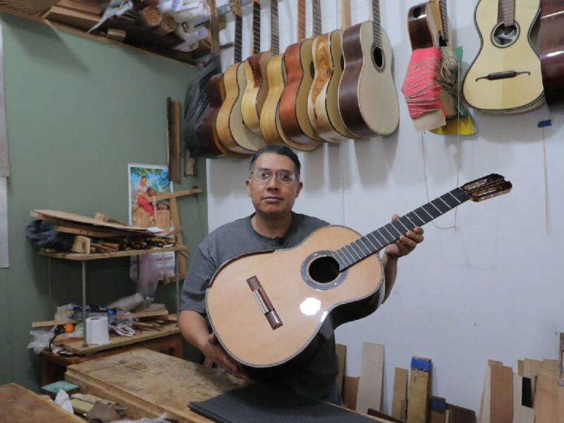 artesano expone sobre guitarras de Paracho en Michoacán